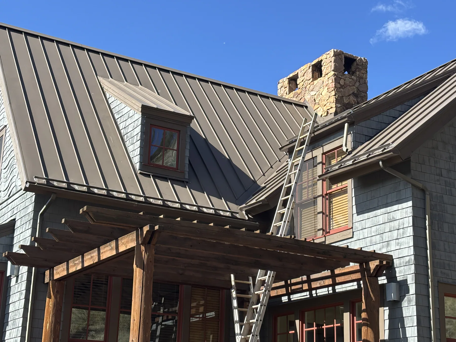 Brown standing-seam roofing across several intersecting roof planes on a home.