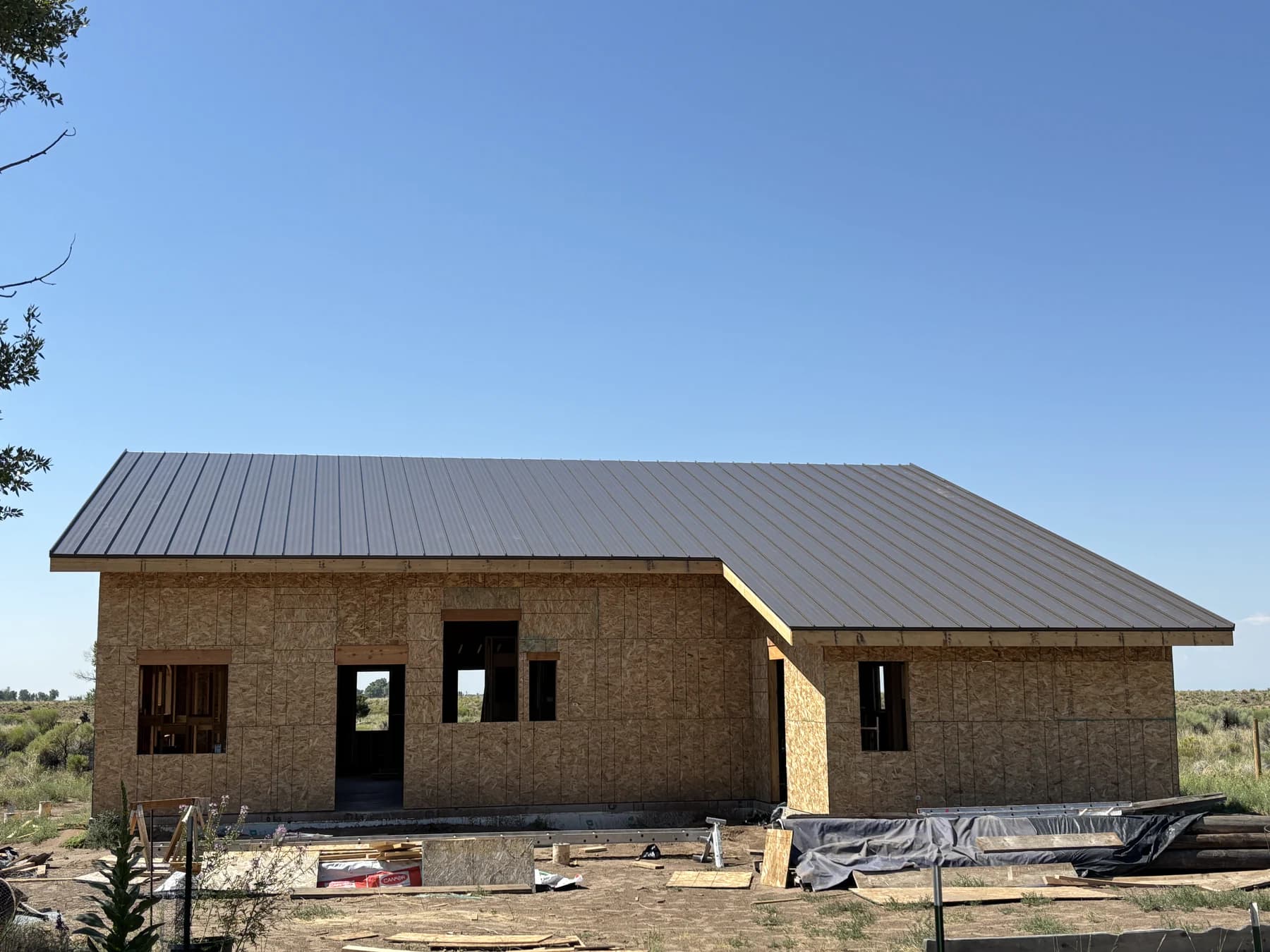 Burnished-slate standing-seam roof above unfinished exterior walls on a new Crestone home