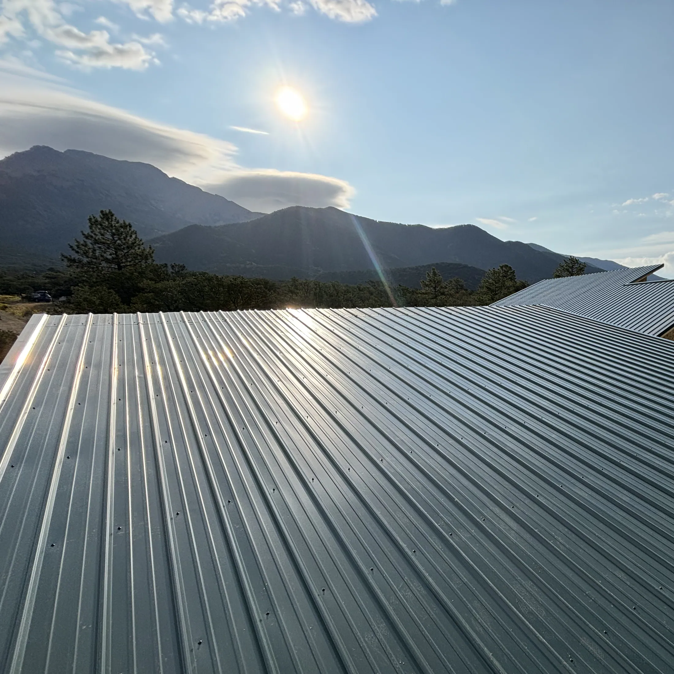 Silver metal roofing against a Colorado mountain horizon